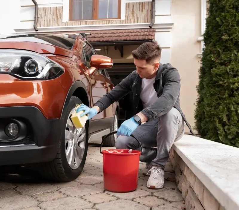 Lavage auto à domicile Corcelles-les-Monts : professionnel intervenant sur un véhicule